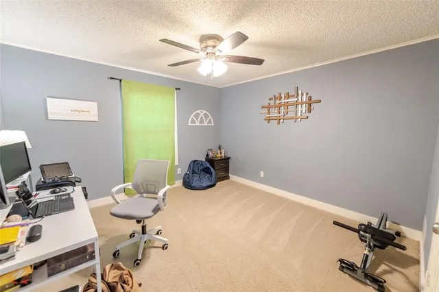 a view of a workspace with furniture and a ceiling fan