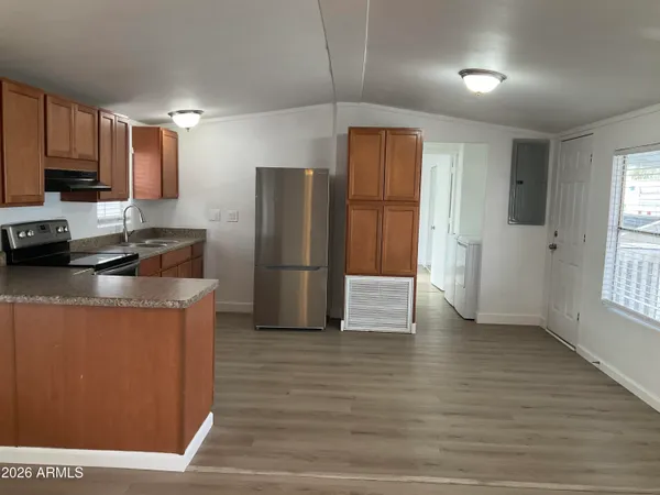a kitchen with stainless steel appliances granite countertop a refrigerator a stove and a wooden floors
