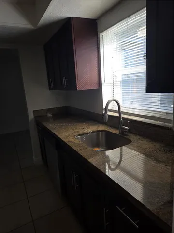 a kitchen with a sink a window and cabinets