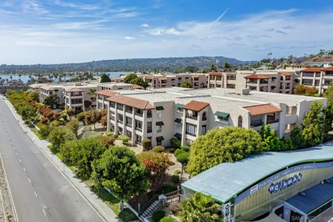 an aerial view of a multi story parking building with swimming pool and lawn chairs