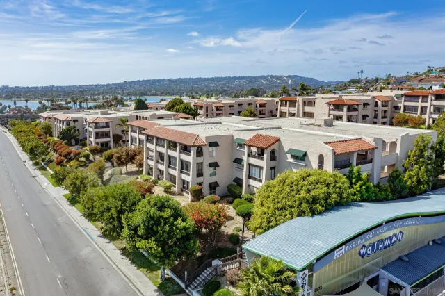 an aerial view of a multi story parking building with swimming pool and lawn chairs