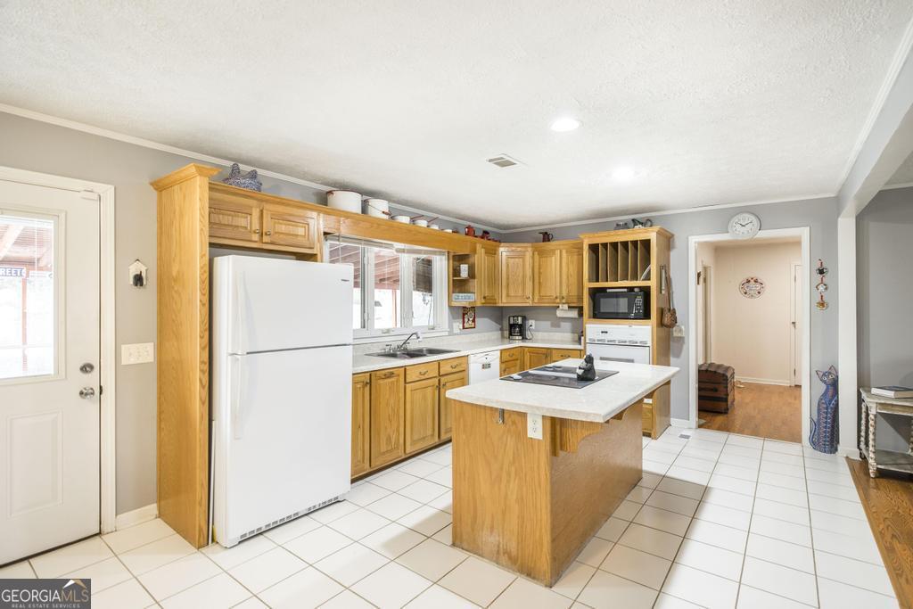 188 Lewis Street Cochran, GA 31014 - Photo 11 of 46 a kitchen with stainless steel appliances granite countertop a refrigerator a sink a stove top oven a counter space and living room view