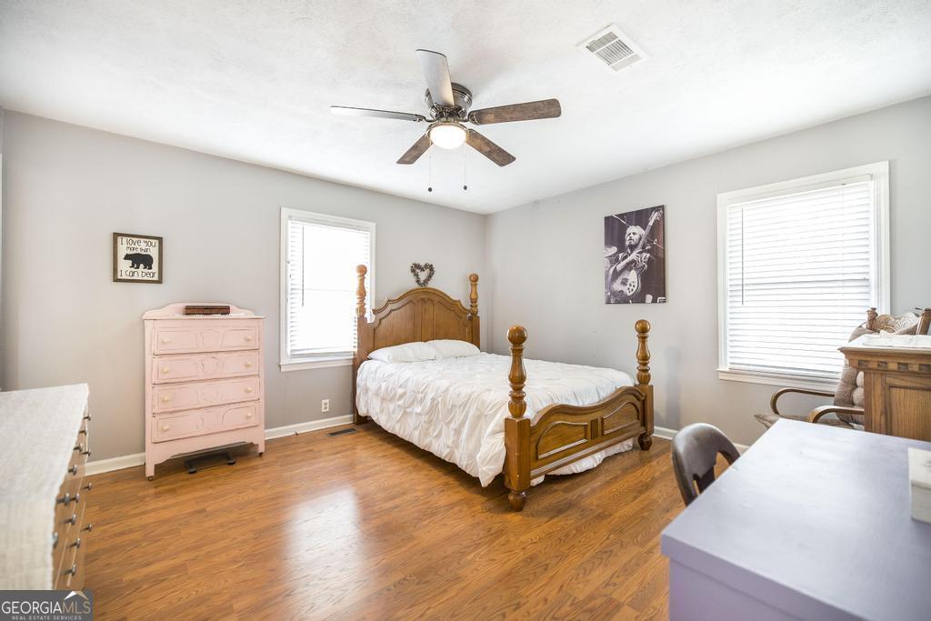 188 Lewis Street Cochran, GA 31014 - Photo 17 of 46 a bedroom with a bed and wooden floor