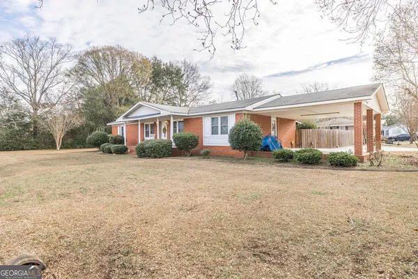 a front view of house with yard and trees around