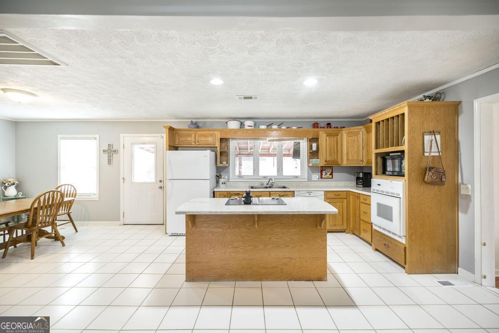 188 Lewis Street Cochran, GA 31014 - Photo 7 of 46 a kitchen with stainless steel appliances granite countertop a stove top oven a refrigerator a sink and white cabinets