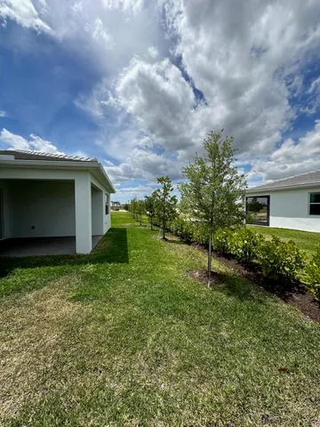 a backyard of a house with plants and barbeque oven