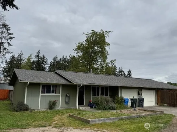 a view of a house with a yard potted plants and a table and chair