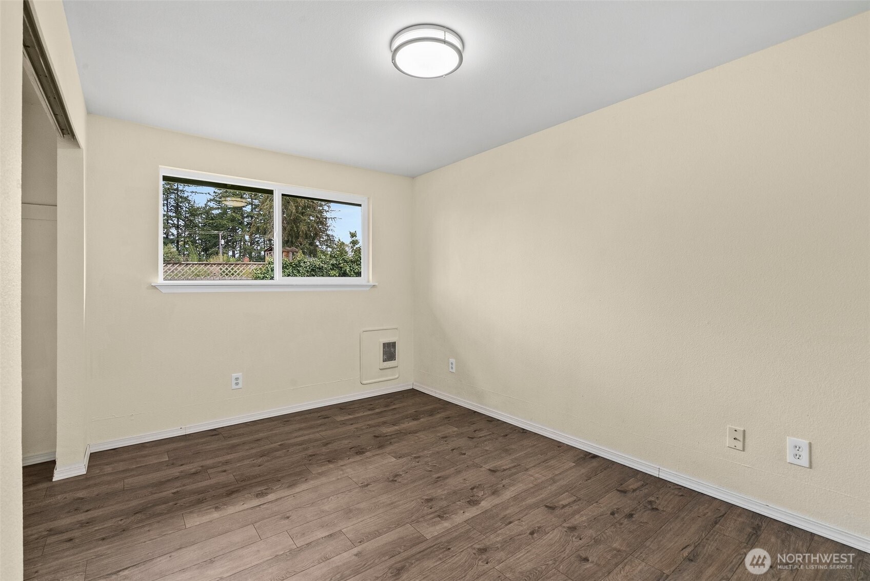 10227-10229 Ainsworth Avenue South Tacoma, WA 98444 - Photo 11 of 23 an empty room with wooden floor and windows