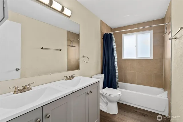 a bathroom with a granite countertop sink toilet a large mirror and a bathtub