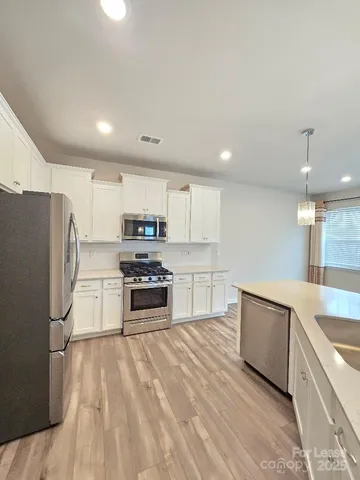 a kitchen with stainless steel appliances a refrigerator sink and stove
