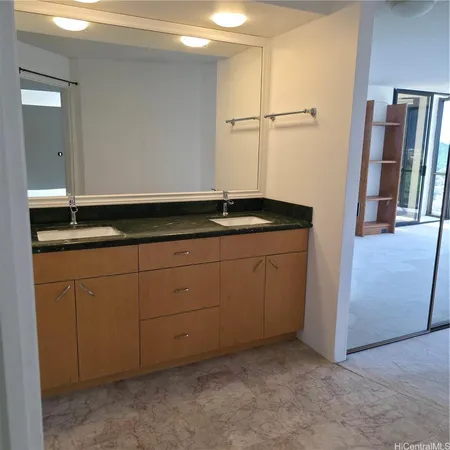 a bathroom with a granite countertop sink and a mirror