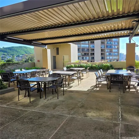 a view of a patio with table and chairs potted plants and palm tree