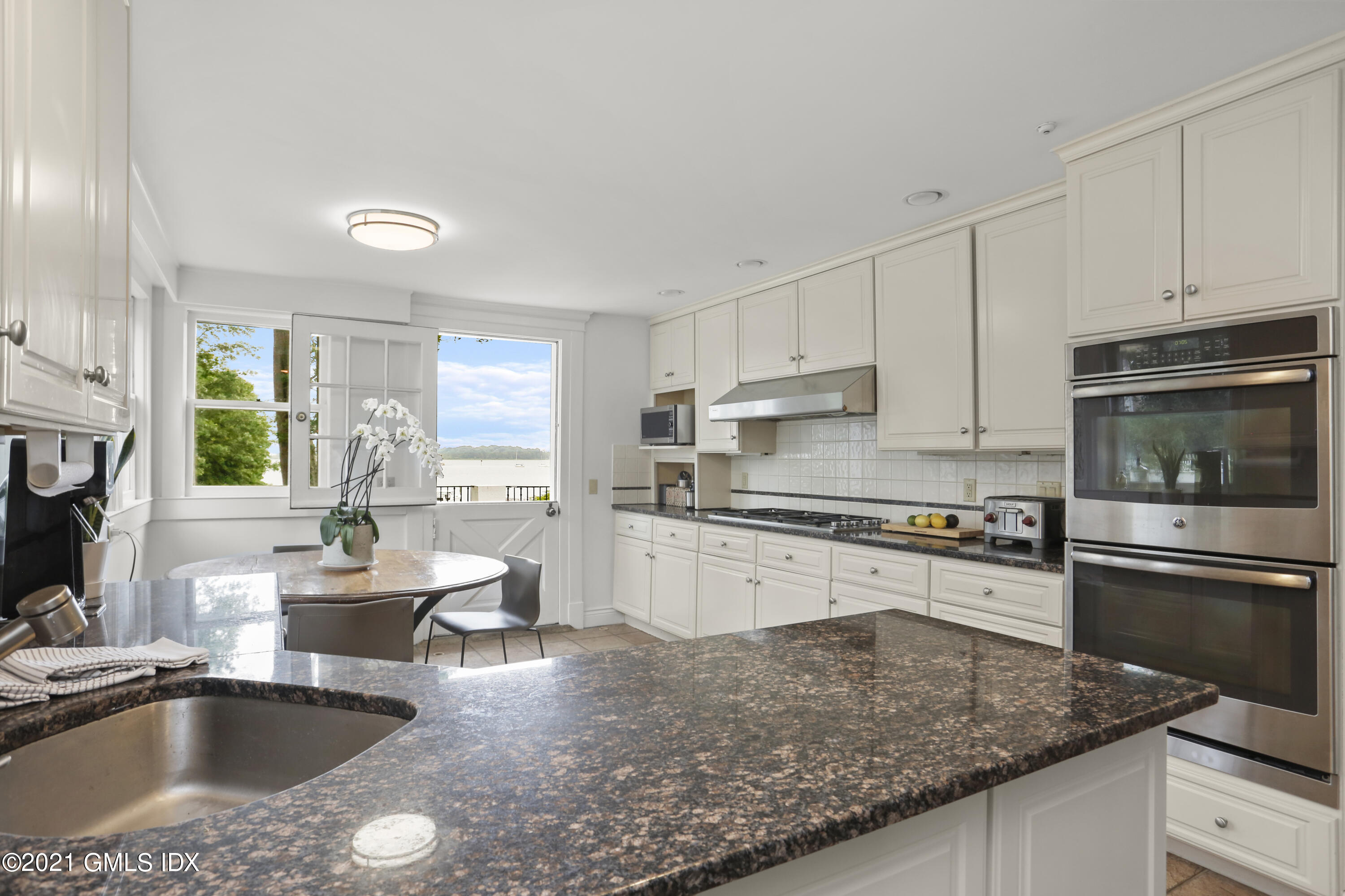 91 Indian Head Road Riverside, CT 06878 - Photo 14 of 45 a kitchen with stainless steel appliances granite countertop a sink stove microwave and refrigerator