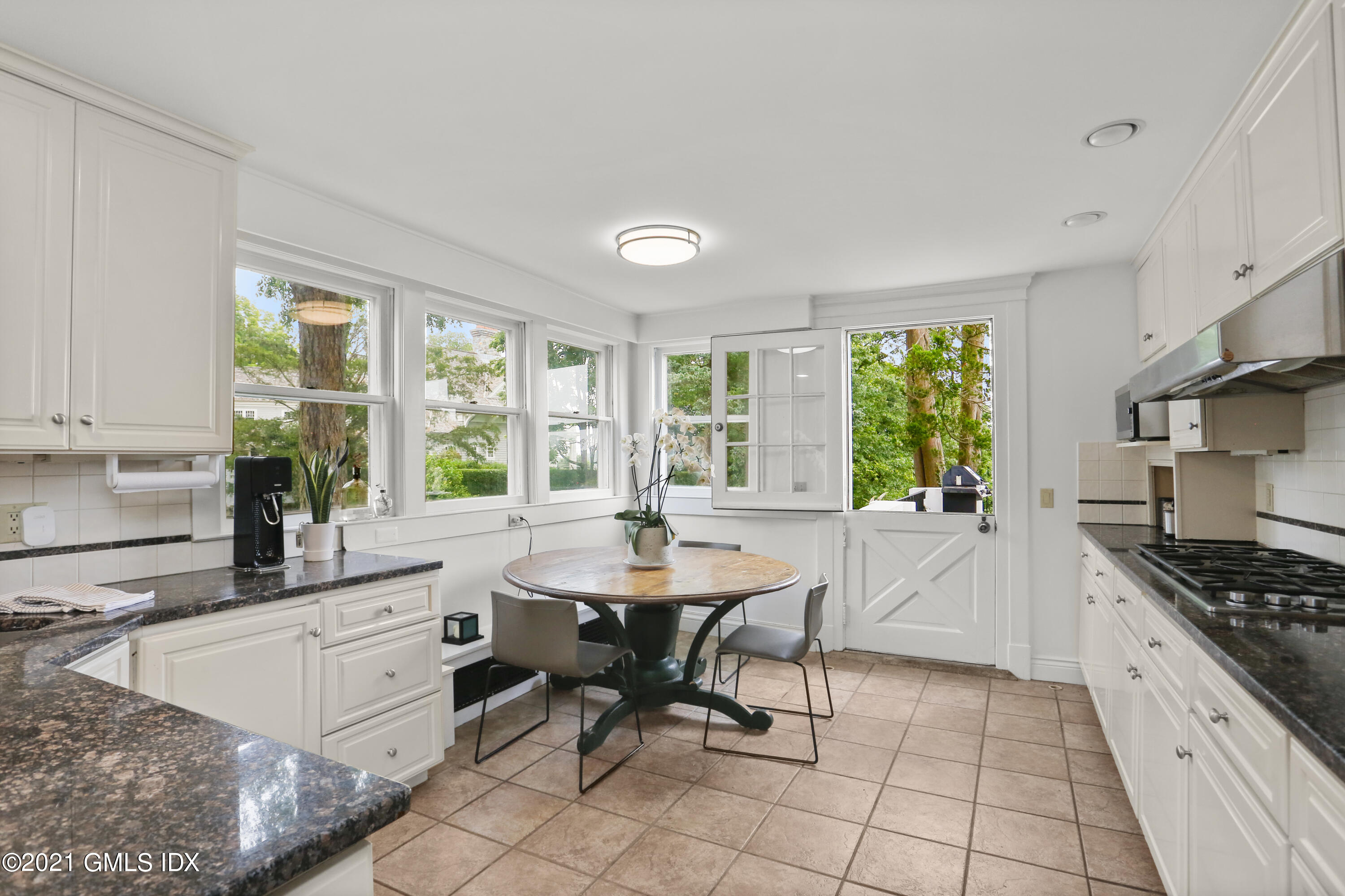 91 Indian Head Road Riverside, CT 06878 - Photo 15 of 45 a kitchen with granite countertop a stove a sink and a dining table view