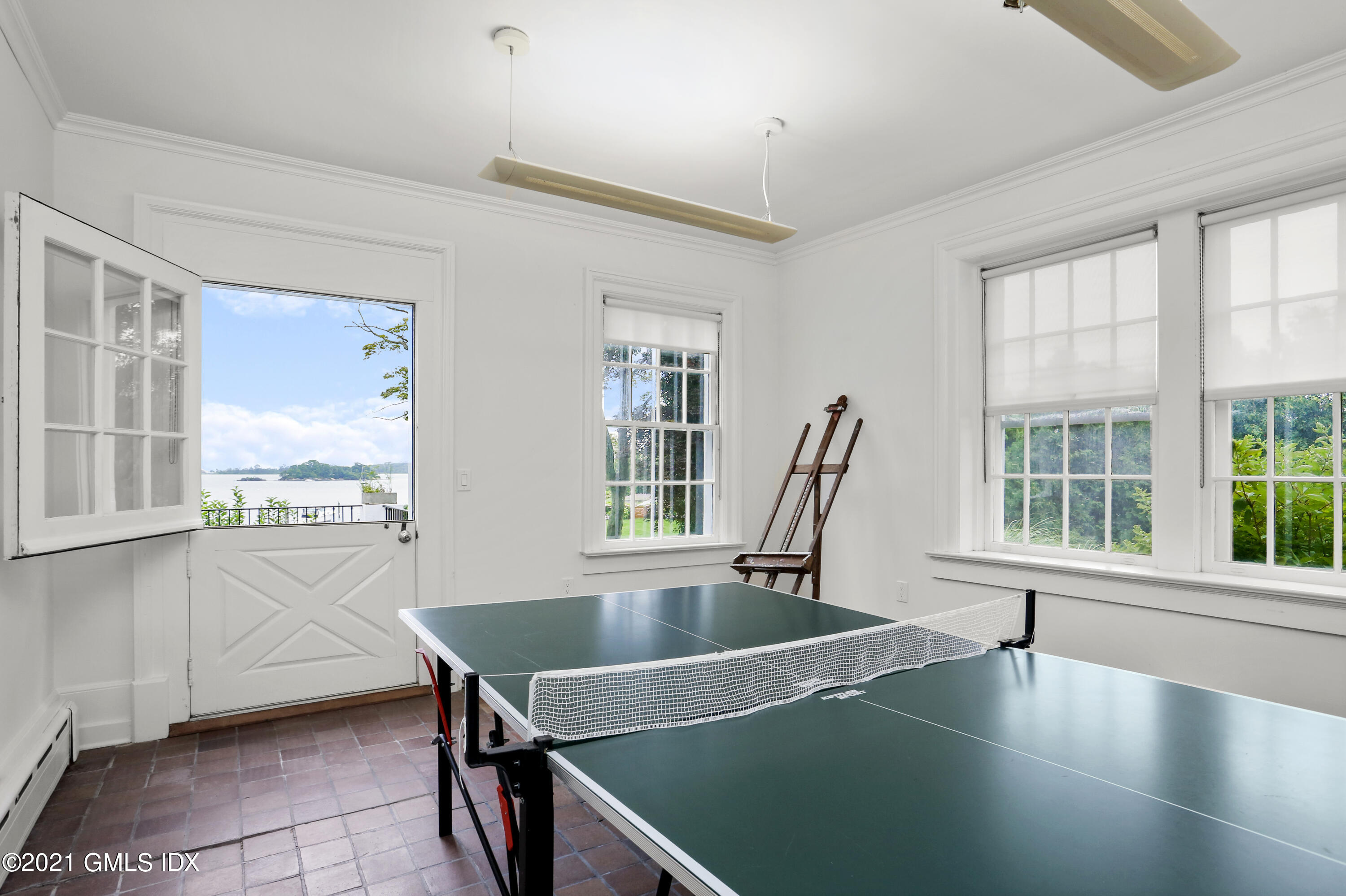 91 Indian Head Road Riverside, CT 06878 - Photo 18 of 45 a dining room with wooden floor and a floor to ceiling window