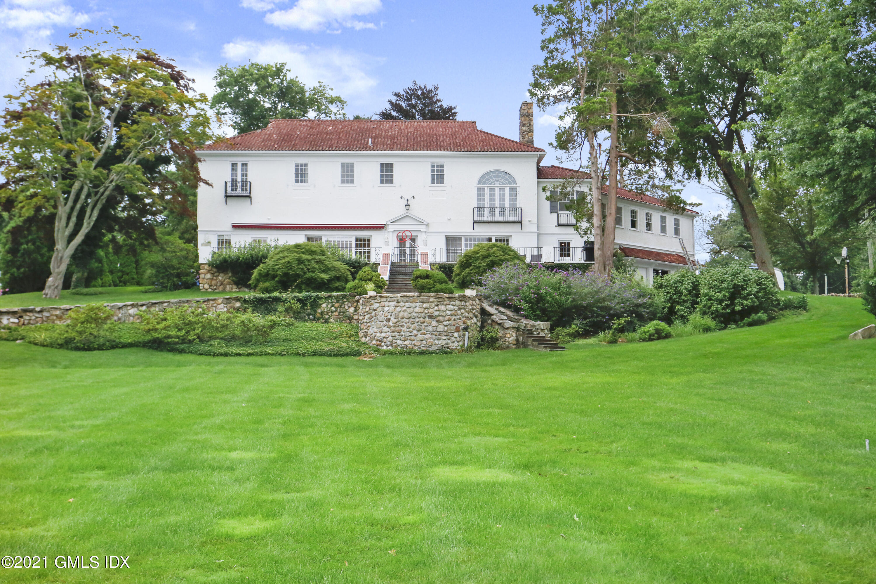 91 Indian Head Road Riverside, CT 06878 - Photo 3 of 45 a front view of a house with a garden