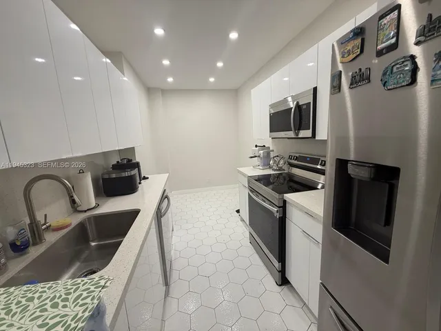 a kitchen with stainless steel appliances granite countertop a sink a stove and a refrigerator