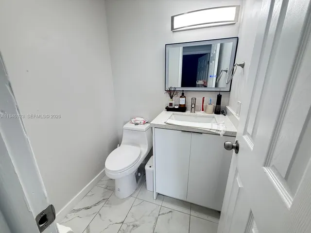 a bathroom with a toilet sink and mirror