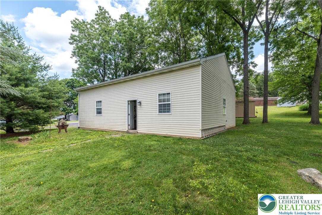 1815 Leithsville Road Hellertown, PA 18055 - Photo 2 of 38 A neatly maintained lawn surrounds this structure, offering ample space and natural privacy from mature trees.