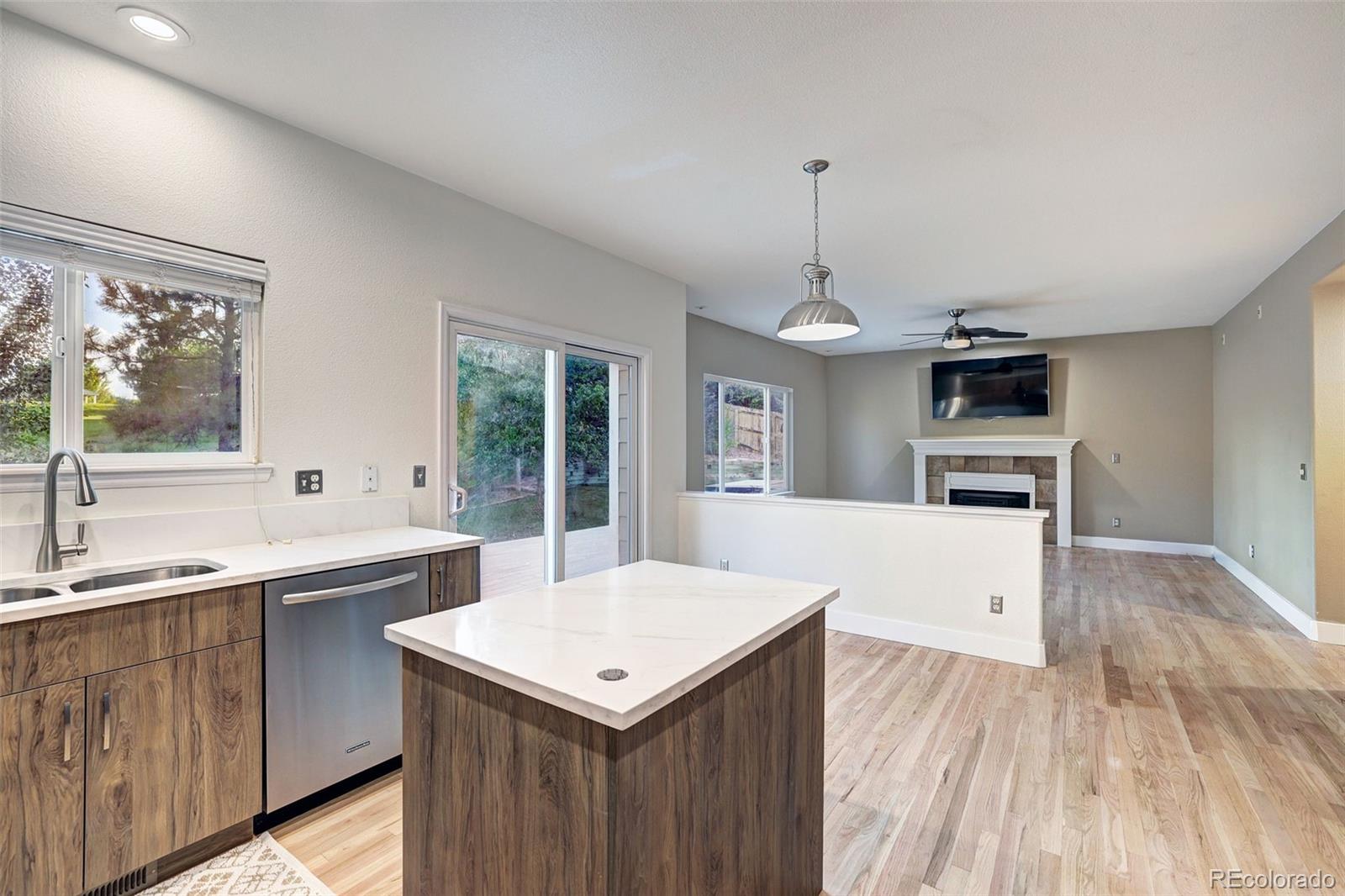 3232 Cimarron Place Superior, CO 80027 - Photo 10 of 43 a kitchen with a sink a kitchen island and stainless steel appliances