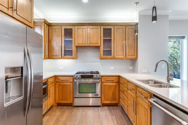 a kitchen with stainless steel appliances granite countertop a stove a sink and a refrigerator