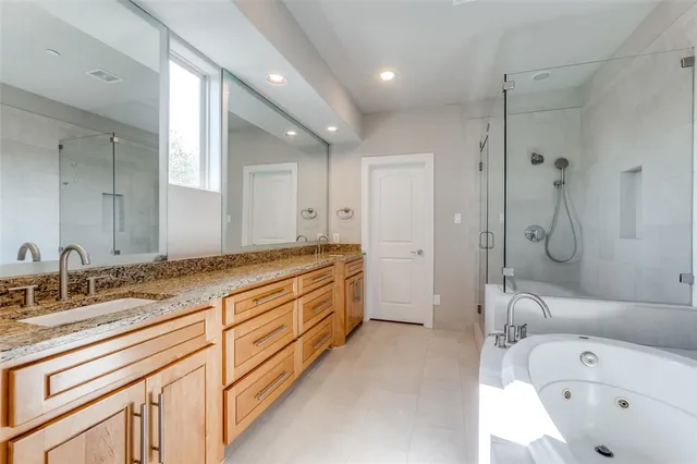 a bathroom with a tub sink double vanity and a shower