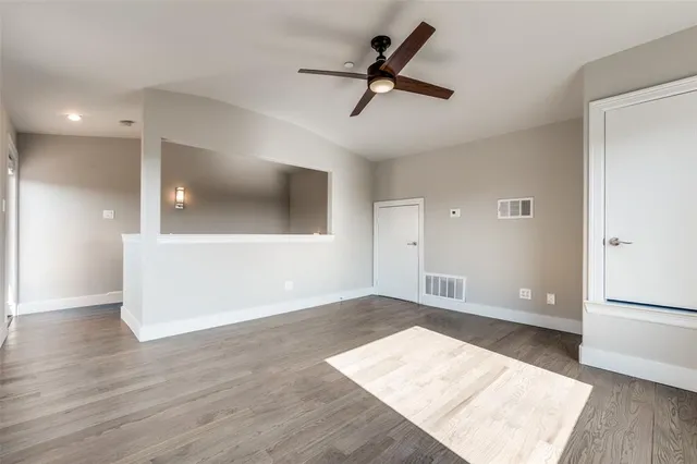 a view of a livingroom with a ceiling fan and wooden floor