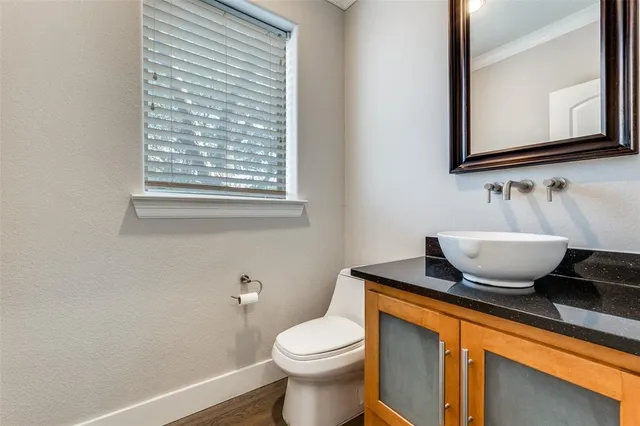 a bathroom with a granite countertop toilet sink and mirror