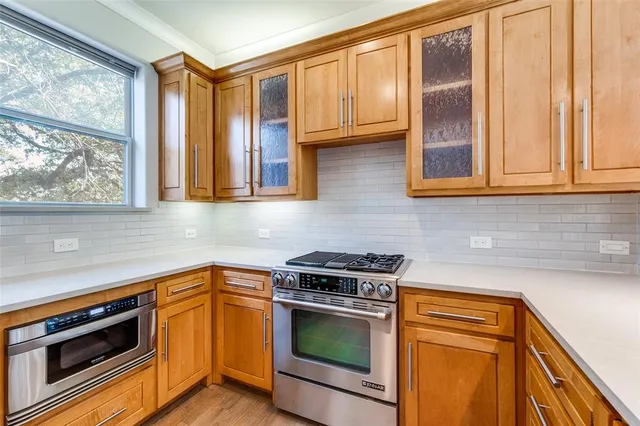 a kitchen with stainless steel appliances wooden cabinets and a stove top oven
