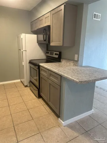 a kitchen with stainless steel appliances granite countertop a refrigerator and a stove