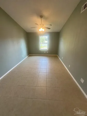 a view of an empty room and window and ceiling fan