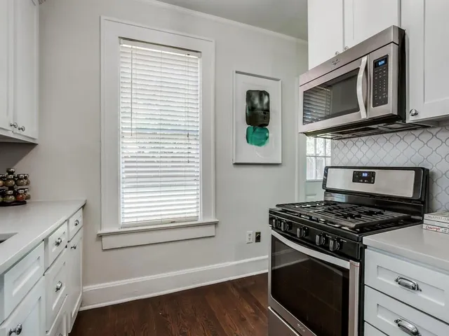 a kitchen with stainless steel appliances a stove microwave and sink