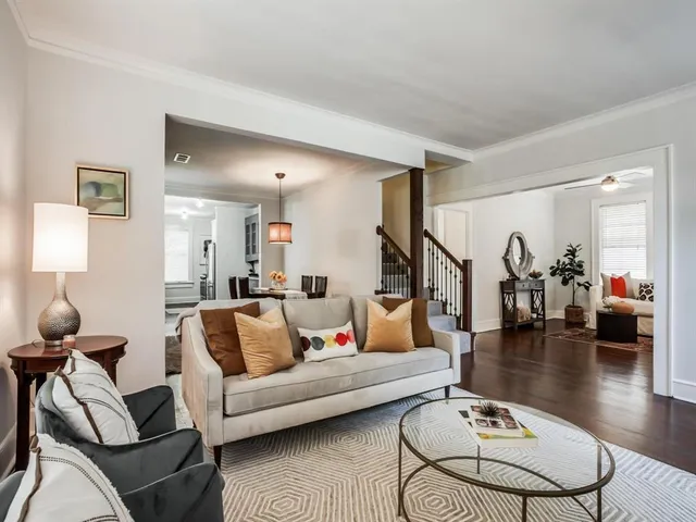a living room with furniture and a dining table with wooden floor