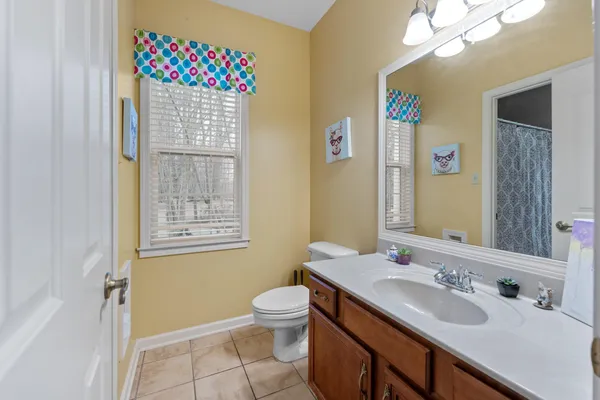 a bathroom with a sink vanity granite and toilet