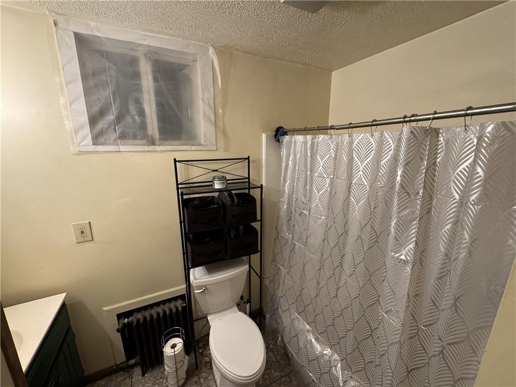 238 Park Road Ambridge, PA 15003 - Photo 11 of 11 a white toilet sitting next to a shower curtain