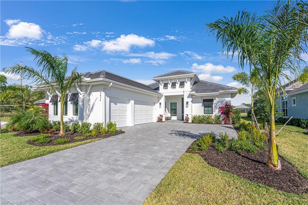 9675 Moonflower Court Naples, FL 34114 - Photo 1 of 32 View of front facade with stucco siding, decorative driveway, an attached garage, and a front lawn
