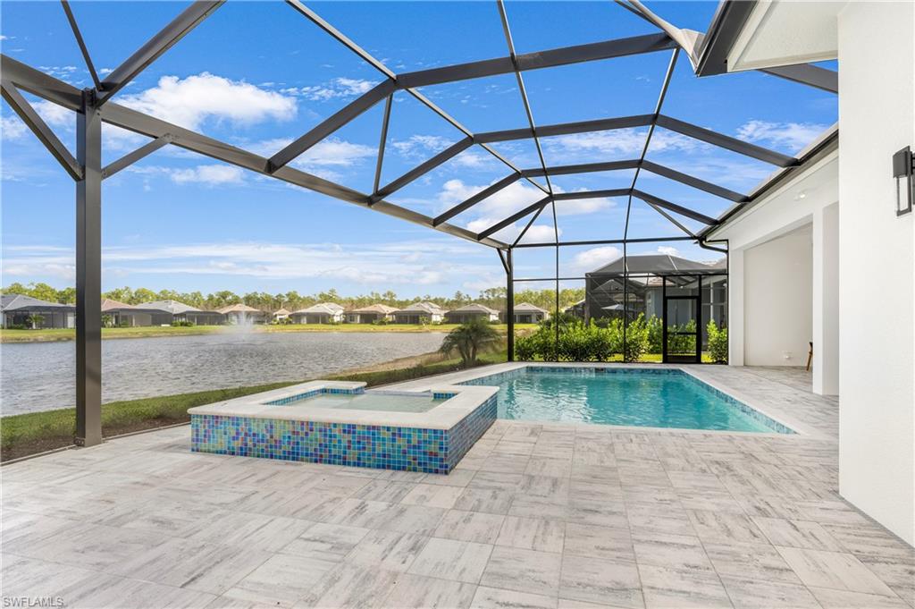 9675 Moonflower Court Naples, FL 34114 - Photo 11 of 32 View of swimming pool with a sunroom, a water view, a residential view, a patio area, and a pool with connected hot tub