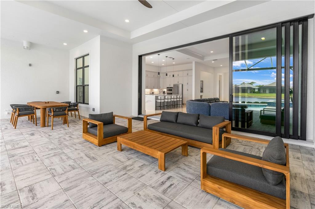 9675 Moonflower Court Naples, FL 34114 - Photo 13 of 32 View of patio / terrace with ceiling fan, outdoor dining area, an outdoor hangout area, and a water view