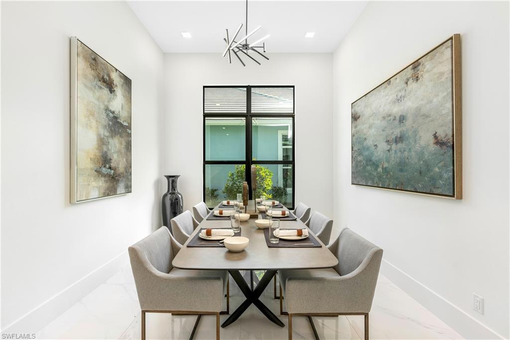 9675 Moonflower Court Naples, FL 34114 - Photo 15 of 32 Dining room featuring a chandelier and marble look tiles