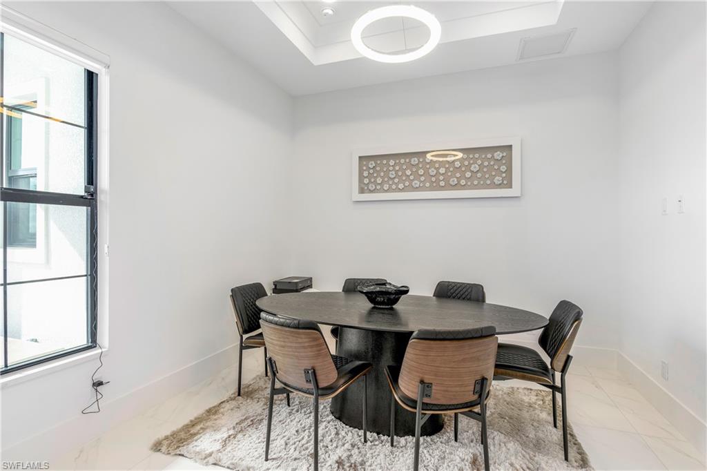 9675 Moonflower Court Naples, FL 34114 - Photo 18 of 32 Dining space featuring a raised ceiling and baseboards