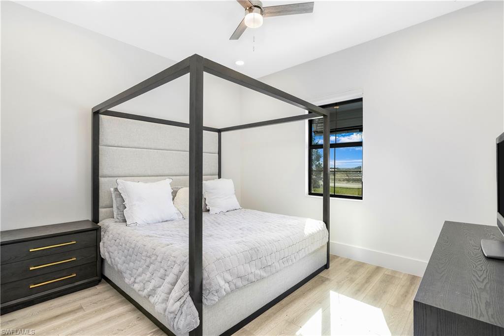 9675 Moonflower Court Naples, FL 34114 - Photo 22 of 32 Bedroom featuring light wood-style flooring and ceiling fan