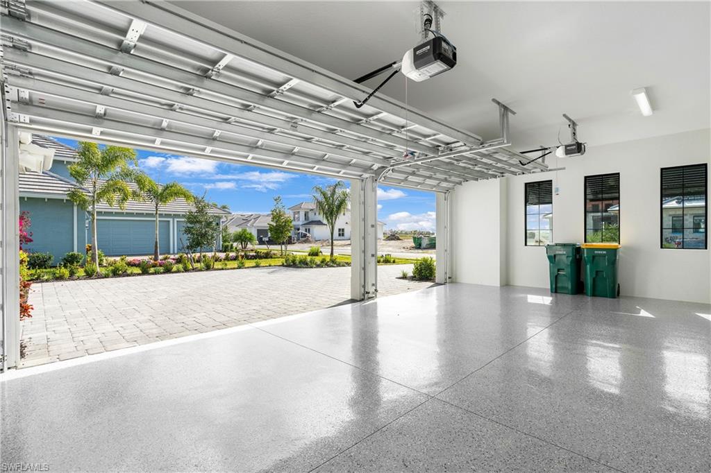 9675 Moonflower Court Naples, FL 34114 - Photo 25 of 32 Garage featuring a garage door opener