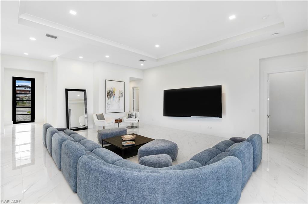 9675 Moonflower Court Naples, FL 34114 - Photo 3 of 32 Living area with light marble finish floors, recessed lighting, and a raised ceiling