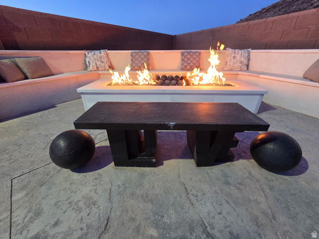 6105 Bunda Way St. George, UT 84790 - Photo 41 of 49 Outdoor living area featuring a built-in fire pit, integrated bench seating, and patterned concrete flooring