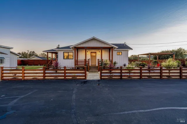 a kitchen with stainless steel appliances a stove a sink a refrigerator a center island a dining table and chairs