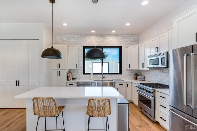 a living room with furniture a flat screen tv and kitchen view