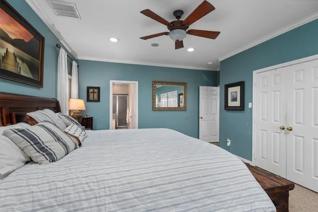 a bedroom with a large bed and a chandelier