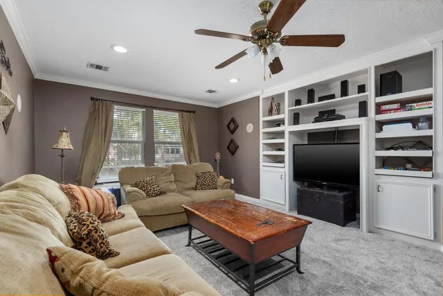a living room with furniture ceiling fan and a window