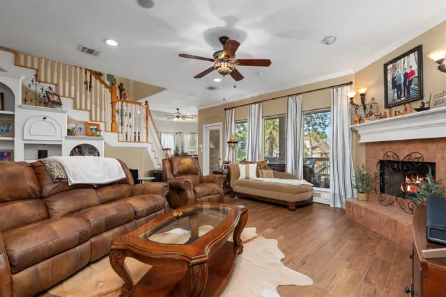a living room with furniture a fireplace and a large window