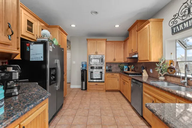 a kitchen with stainless steel appliances granite countertop a refrigerator stove and oven